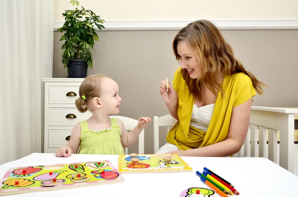 Mother and little girl painting at a table