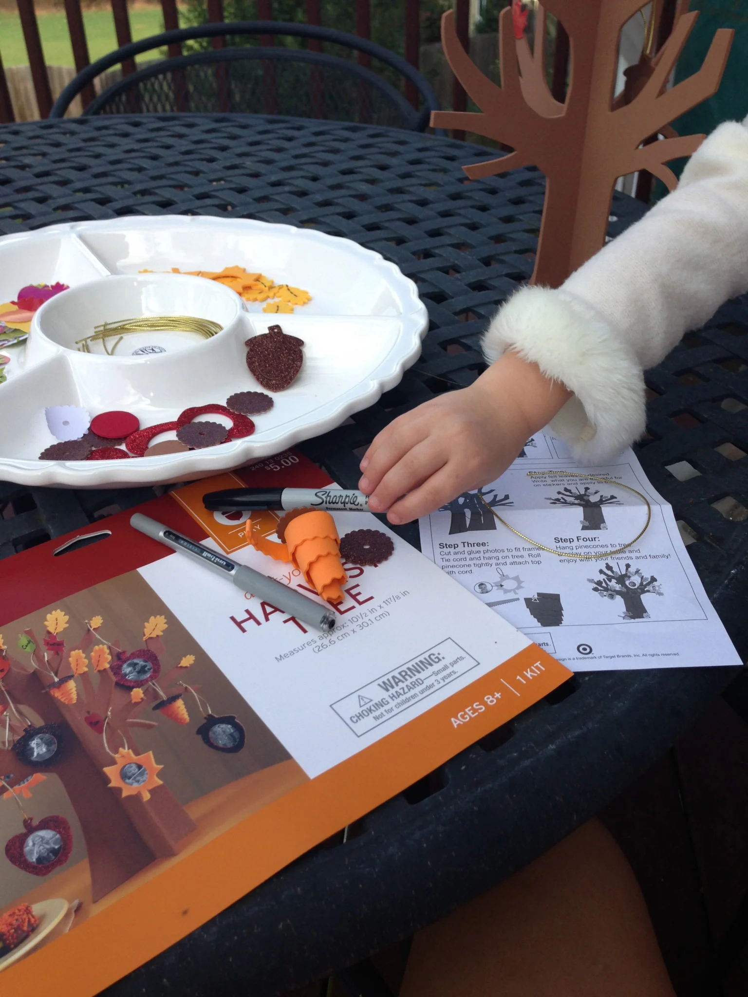 Child assembling a fall paper tree craft at a table