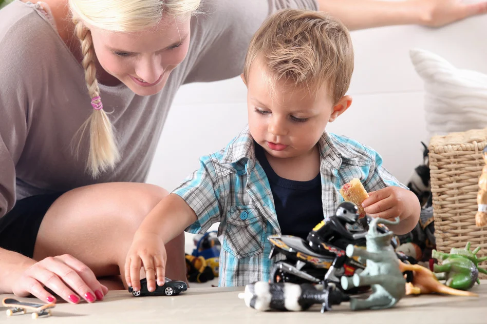 Mother and young boy playing with toy cars