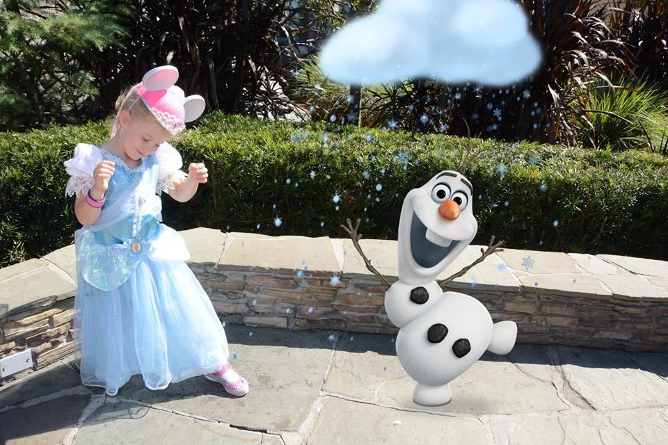 Little girl in a princess dress with an Olaf toy
