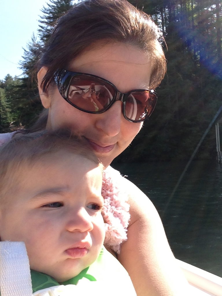 Woman in sunglasses holding a baby outdoors
