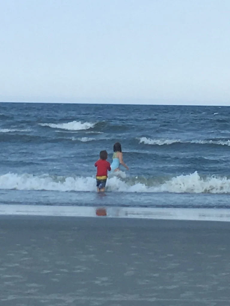 Children playing in the ocean waves at the beach