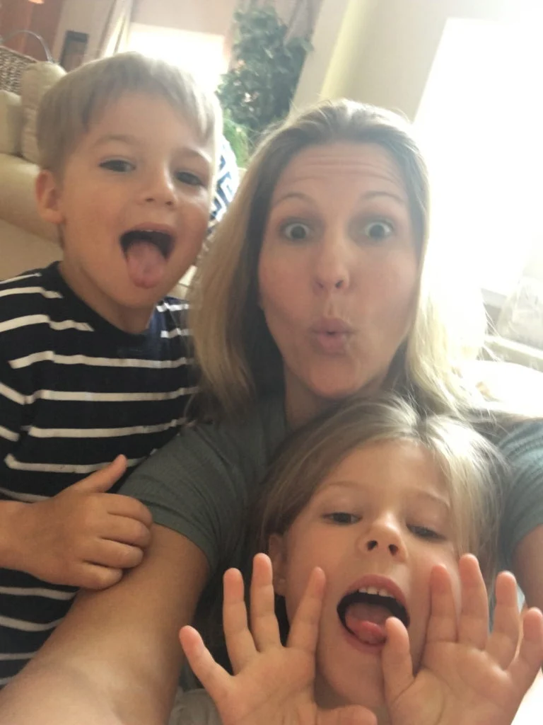 Woman and two children making silly faces in a selfie