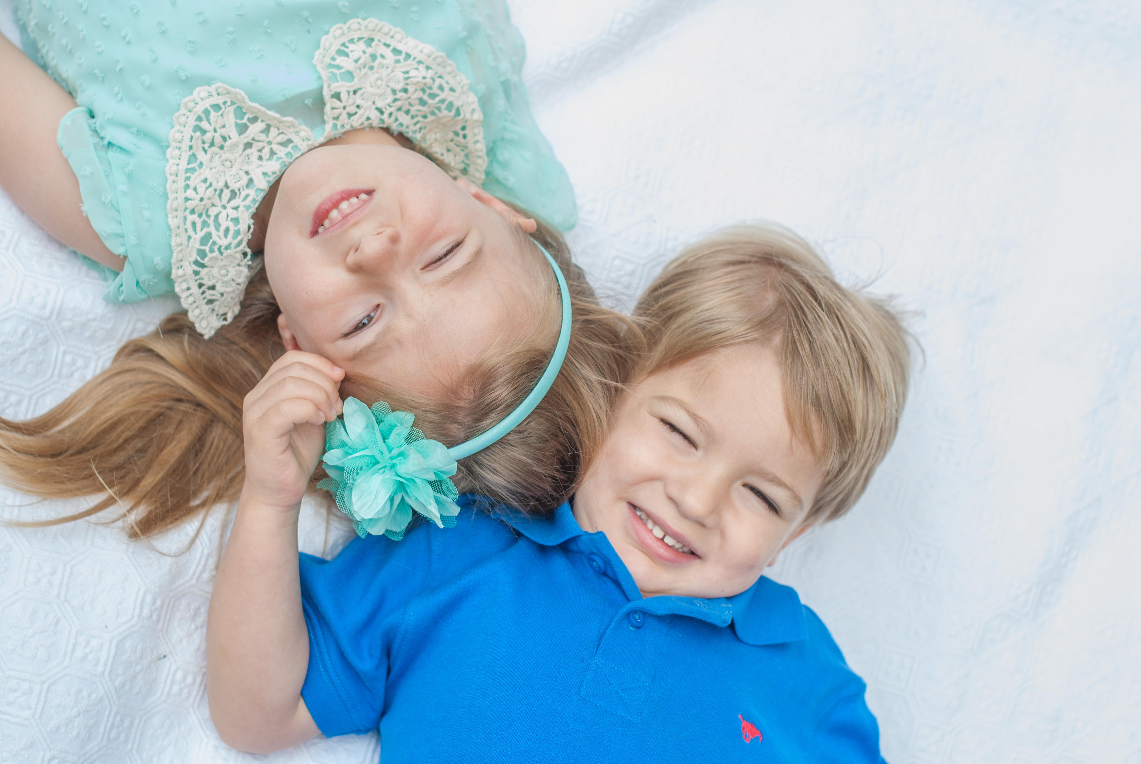 Girl and boy laying down laughing.