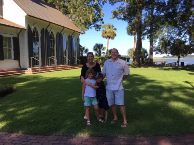 Family on the lawn of a waterfront home in Palmetto Bluff