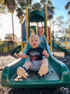 Toddler going down a playground slide