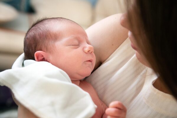 Newborn care specialist in Charlotte soothing a sleeping infant at night