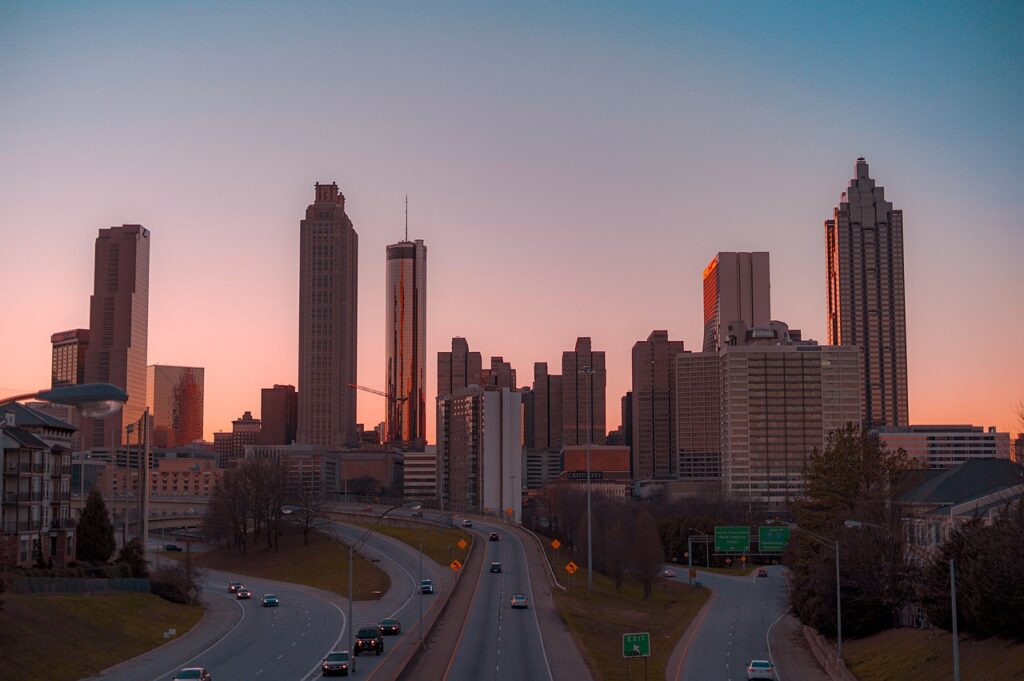 Atlanta skyline at dusk with Georgia's Dream Nannies logo/branding for premium nanny services.