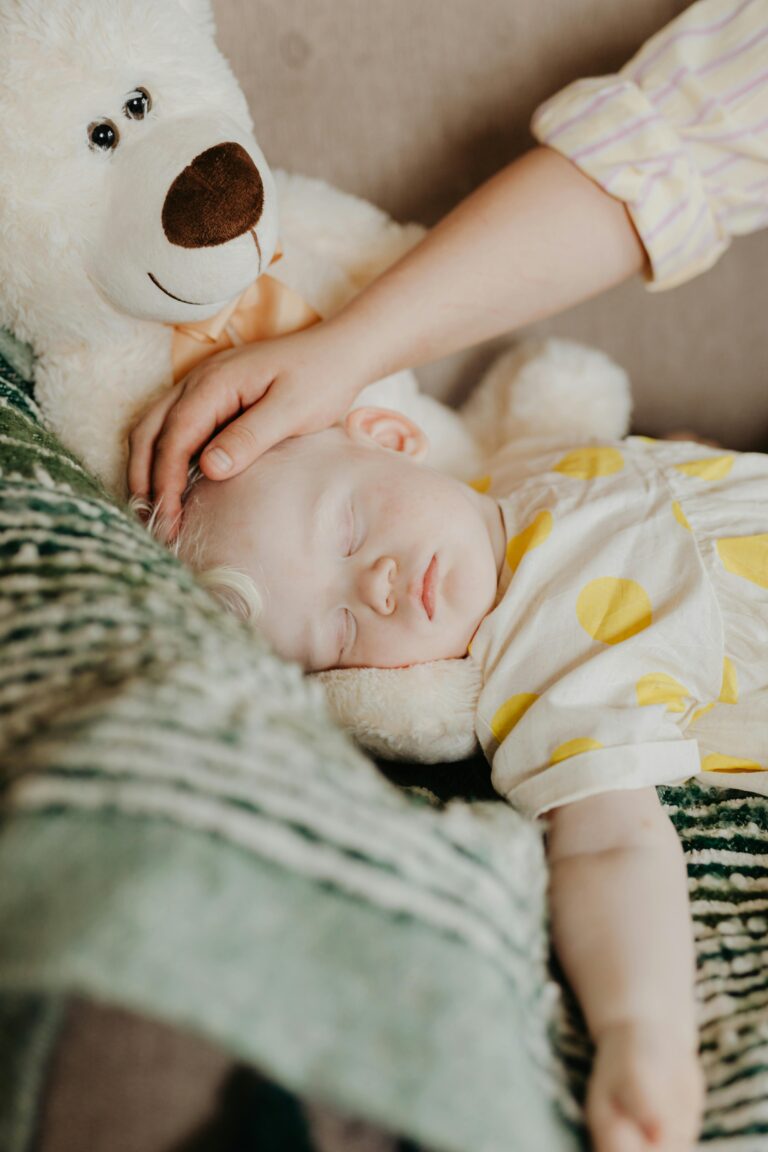 Baby sleeping beside a teddy bear