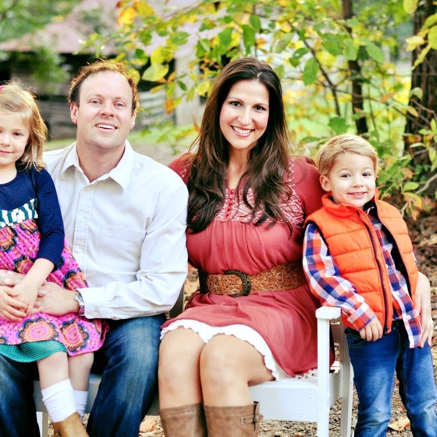 Serra Deville and Don Deville seated with their daughter and son in an autumn family portrait